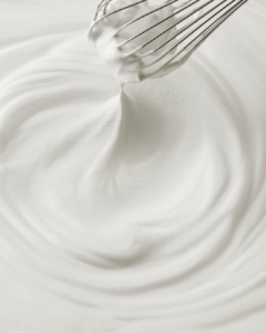Gros plan d’une mousse blanche onctueuse fouettée au fouet pour soin corps sensoriel