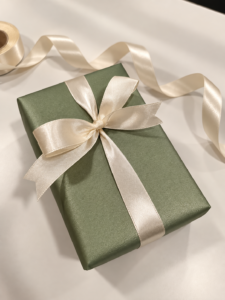 Cadeau emballé à la main dans un papier vert et un ruban crème, institut Réactuel à Gouvieux